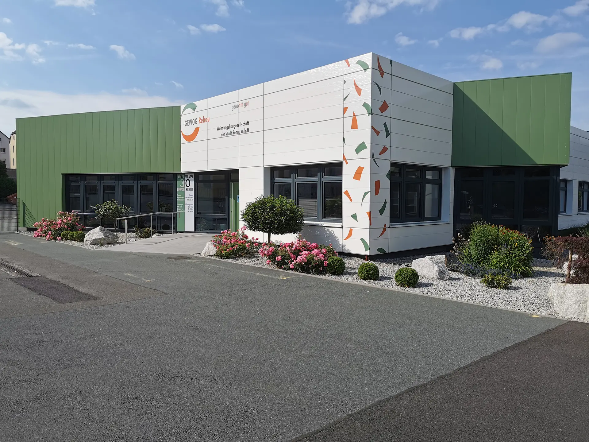Außenansicht des GEWOG Gebäudes mit Fahrzeugen im Vordergrund